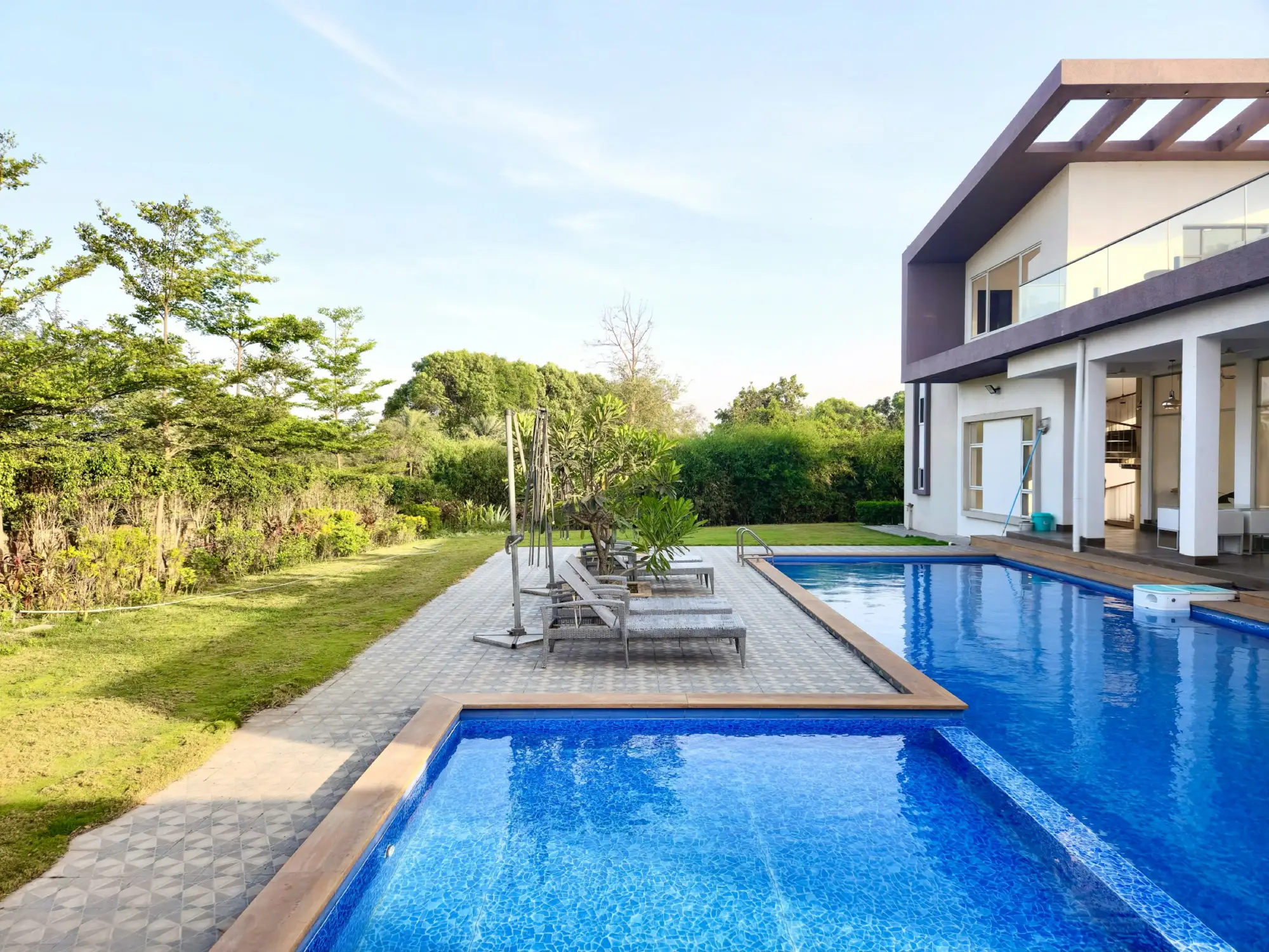 Piscina accanto a una villa con giardino